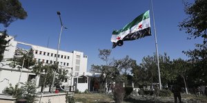 Η σημαία της Συρίας κυματίζει έξω από το υπουργείο Άμυνας στη Δαμασκό, που χτυπήθηκε πρόσφατα από το Ισραήλ