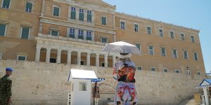 Τουρίστρια με ομπρέλα έξω από τη Βουλή