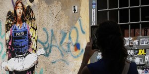 Γκράφιτι με δημοσιογράφο να κρατάει μωρό στη Γάζα