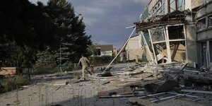 Ανδρας τρέχει σε σημείο με ζημιές από βομβαρδισμό στην Ουκρανία