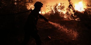 Πυροσβέστης επιχειρεί για την κατάσβεση της φωτιάς τη νύχτα