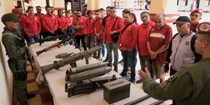 Στρατιωτικοί της Βενεζουέλας δείχνουν σε πολίτες τη χρήση όπλων