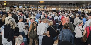 Άνθρωποι περιμένουν στην ουρά για να κάνουν check-in μετά από μια κυβερνοεπίθεση που προκάλεσε καθυστερήσεις στο Διεθνές Αεροδρόμιο των Βρυξελλών