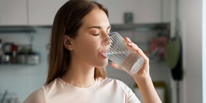 Γυναίκα πίνει νερό από ποτήρι