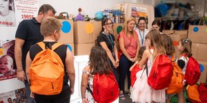 Οι εργαζόμενοι του ΟΠΑΠ μοιράζουν τις τσάντες με τα σχολικά είδη στα παιδιά του Οργανισμού