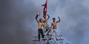 Νέοι στέκονται στην κορυφή κτιρίου με γραφεία υπουργείων του Νεπάλ