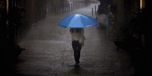 Γυναίκα με ομπρέλα στη μέση του δρόμου