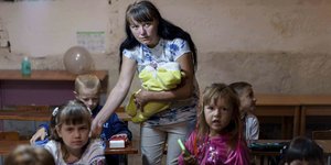 Μια μητέρα βοηθά τον γιο της να προετοιμαστεί για το μάθημα, στο υπόγειο ενός δημοτικού κτιρίου κατά την πρώτη μέρα του σχολείου στο Σούμι της Ουκρανίας