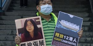 Ανδρας κρατάει πλακάτ της δημοσιογράφου που δημοσίευσε την έξαρση του κορωνοιού