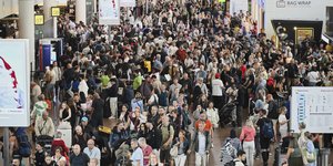 Άνθρωποι περνούν μπροστά από τον πίνακα αναχωρήσεων στο Διεθνές Αεροδρόμιο των Βρυξελλών, μετά από μια κυβερνοεπίθεση που προκάλεσε καθυστερήσεις