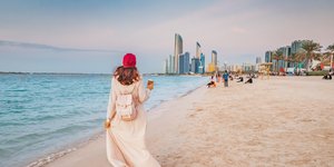 Δυτική γυναίκα περπατά σε παραλία του Άμπου Ντάμπι