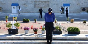 Μία αστυνομικός μπροστά από τον Άγνωστο Στρατιώτη και τα 57 ονόματα των Τεμπών