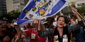 Ισραηλινοί με σημαία της χώρας της και φωτογραφίες ομήρων