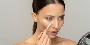 Γυναίκα που βάζει concealer