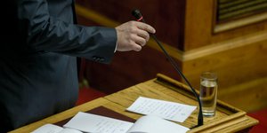 Ομιλητής στη Βουλή κρατά το μικρόφωνο