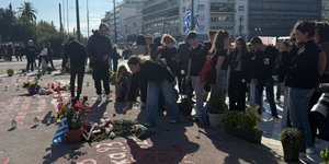 Μαθητές αφήνουν λουλούδια στο σημείο με τα ονόματα των νεκρών των Τεμπών