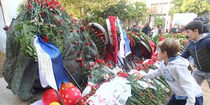 Παιδιά αφήνουν λουλούδια στο μνημείο του Πολυτεχνείου