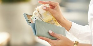 Χέρια που κρατούν ένα γεμάτο πορτοφόλι 