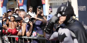 Θεατές φωτογραφίζουν έναν άνδρα ντυμένο ως Μπάτμαν