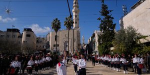 Παλαιστινιακές ομάδες προσκόπων παρελαύνουν στην εκκλησία της Γεννήσεως, στη Βηθλεέμ την παραμονή των Χριστουγέννων 