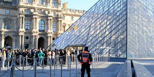 Η εμβληματική είσοδος-πυραμίδα στο μουσείο του Λούβρου, γεμάτη επισκέπτες
