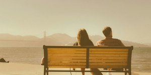 Ζευγάρι κάθεται σε παγκάκι 