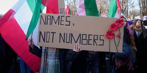 «Ονόματα, όχι αριθμοί» αναγράφεται σε πλακάτ, σε συγκέντρωση αλληλεγγύης υπέρ των διαδηλωτών στο Ιράν