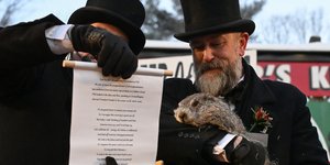 Ο υπεύθυνος του Groundhog Club A.J. Dereume κρατά τον Punxsutawney Phil, τη μαρμότα που προβλέπει τον καιρό, ενώ ο αντιπρόεδρος του συλλόγου Dan McGinley διαβάζει τον πάπυρο στις 2 Φεβρουαρίου 2026 /
