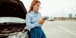 Γυναίκα που ακουμπάει σε αυτοκίνητο με κινητό