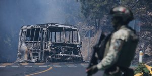 Στρατιώτης στο Μεξικό μπροστά από καμμένο φορτηγό
