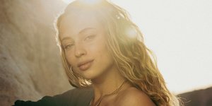 Νεαρή γυναίκα με ξανθά μαλλιά κάτω από τον ήλιο