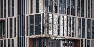 Η μερικώς κατεστραμμένη πρόσοψη ενός κτιρίου στην οικονομική περιοχή του Ντουμπάι, από πτώση συντριμμιών drone - 13 Μαρτίου 2026. (AP Photo/Altaf Qadri)