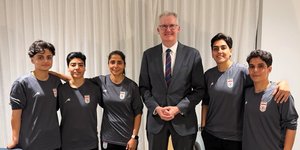 O Υπουργός Εσωτερικών της Αυστραλίας, Τόνι Μπερκ, στο κέντρο, ποζάρει σε άγνωστη τοποθεσία με τις πέντε Ιρανές ποδοσφαιρίστριες στις χορηγήθηκε άσυλο, Τρίτη 10 Μαρτίου 2026 – Φωτ: ΑΡ