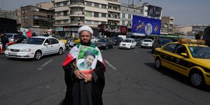 Κληρικός στο κέντρο της Τεχεράνης κρατά φωτογραφία του ανώτατου θρησκευτικού ηγέτη του Ιράν, Μοτζτάμπα Χαμενεΐ