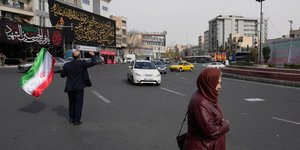 Άνδρας με σημαία του Ιράν στο κέντρο της Τεχεράνης