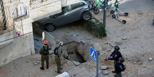 Ισραηλινοί στρατιώτες σε σημείο του Τελ Αβίβ που δέχθηκε εχθρικό πλήγμα 