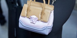 Γυναίκα με δερμάτινη τσάντα Versace με το χαρακτηριστικό κεφάλι της Μέδουσας