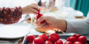 κόκκινα αβγά πασχαλινά που τσουγκρίζουν δύο άτομα