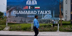 Πεζός περνά από αφισα για τις διαπραγματεύσεις στο Ισλαμαμπάντ