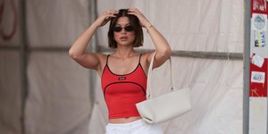 νέα γυναίκα με κόκκινη μπλούζα και γυαλιά ηλίου