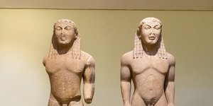 Δύο αγάλματα κούρων τοποθετημένα δίπλα-δίπλα στο Μουσείο των Δελφών