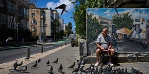 Άνδρας στο Τελ-Αβίβ του Ισραήλ ταΐζει πουλιά την επομένη της συμφωνίας για εκεχειρία με το Ιράν