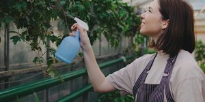 Γυναίκα ψεκάζει φυτά