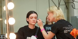 μοντέλο και μακιγιέζ backstage σε επίδειξη μόδας