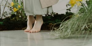 πόδια χωρίς παπούτσια σε φόντο με λουλούδια