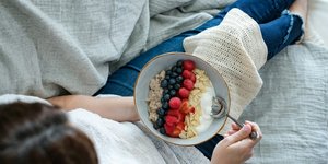 γυναίκα τρώει πρωινό με γιαούρτι και βρώμη