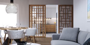 Το συρόμενο, διάτρητο διαχωριστικό από ξύλο επιτρέπει τη διακριτική οριοθέτηση της κουζίνας από το καθιστικό/ Φωτογραφία: Κυριακή Καπασακαλίδου