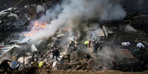 Κάτοικοι και διασώστες πάνω σε συντρίμμια από μια πολυκατοικία που χτυπήθηκε στη Βηρυτό, πρωτεύουσα του Λιβάνου