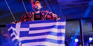 Ο Akylas στο Wiener Stadthalle κρατώντας την ελληνική σημαία 