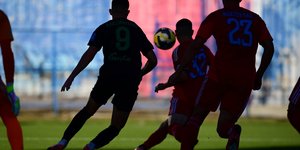 Εικαστική φωτογραφία από αγώνα της Super League 2 με τρεις ποδοσφαιριστές να διεκδικούν την μπάλα